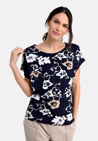 Floral printed short-sleeve top in navy with white and beige patterns, boat neckline, and a relaxed fit, made from soft, lightweight fabric.