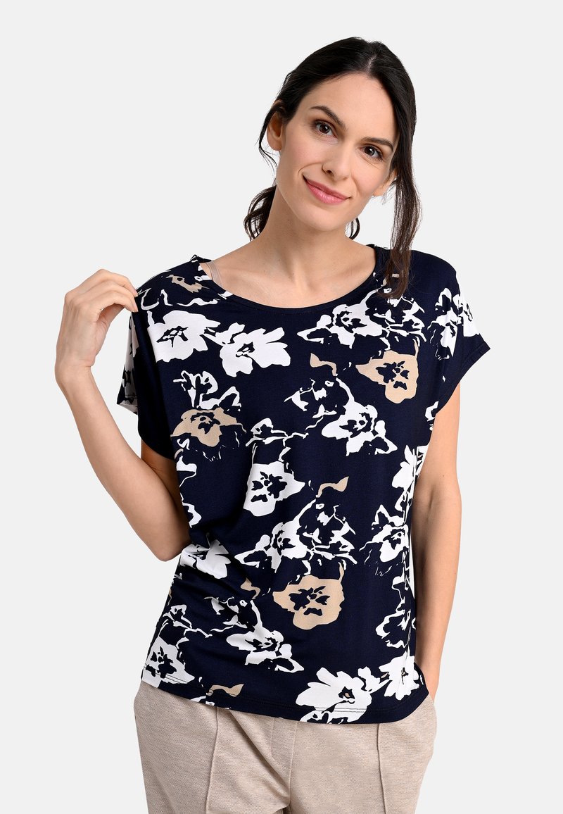 Floral printed short-sleeve top in navy with white and beige patterns, boat neckline, and a relaxed fit, made from soft, lightweight fabric.