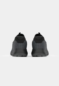 Black athletic shoes with a textured gray upper, padded collar, and pull tab, featuring a textured black outsole for traction.