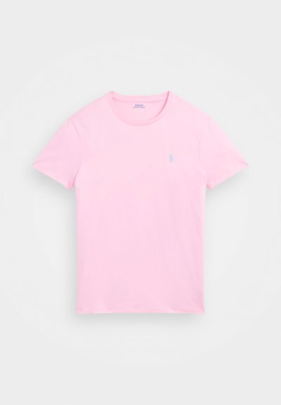 Rózsaszín pamut póló rövid ujjakkal és kerek nyakkal. Bal mellen egy kis, világoskék logó található. Puha tapintású.