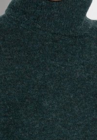 Maglione a collo alto verde scuro realizzato in soffice lana, caratterizzato da un motivo a maglia texturizzato e un collo alto per una maggiore copertura.