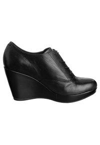 Black leather wedge shoe with a smooth texture, rounded toe, and front lace-up detail. Features a curved platform sole for added height.