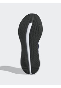 Semelle en caoutchouc noir avec motifs de traction texturés, dotée d'une ligne de semelle intermédiaire blanche et d'un design épuré.