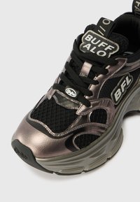 Sapatilhas pretas e em bronze metálico, fabricadas com materiais de malha e couro sintético. Apresentam o logótipo BFL na lateral e atacadores pretos com uma aba de puxar.