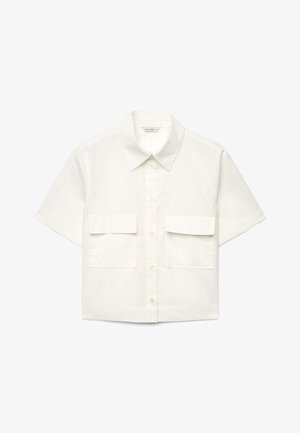 Camicia bianca a maniche corte con colletto, chiusura frontale con bottoni e due grandi tasche con patta sul petto.
