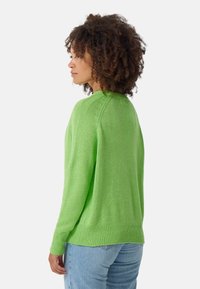 Groene gebreide trui met een geribbelde zoom en textuurdetails op de schoudernaad, relaxte pasvorm en lange mouwen. Casual stijl.