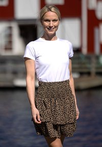 Hvid kortærmet t-shirt parret med en brun leopardmønstret lagdelt nederdel, der har en smocket talje og blød, flydende stof.