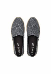 Sapatos slip-on de tecido preto com bolinhas brancas, painéis laterais elásticos, sola texturizada e logotipo no interior.