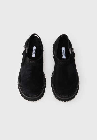 Pantofi slip-on negri din suede, cu o finisare texturată, prezentând o talpă din cauciuc, accesorii din metal și un interior capitonat pentru confort.