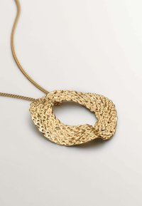 Collar de oro con un colgante texturizado y retorcido en forma de círculo abierto, con una cadena de eslabones. La superficie presenta un patrón martillado.