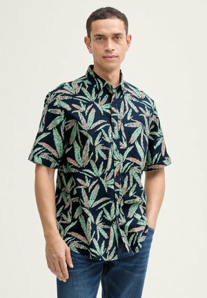 Chemise à manches courtes avec une base bleue ornée de motifs de feuilles vertes et roses. Le tissu semble léger et texturé, avec un design classique à bouton.