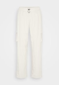 Světlé béžové cargo kalhoty vyrobené z texturované tkaniny, s elastickým pasem na šňůrku a bočními kapsami.