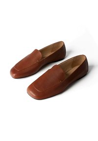 Paire de mocassins marron en cuir à enfiler, avec bouts carrés et semelles basses noires, présentés sur un fond blanc.