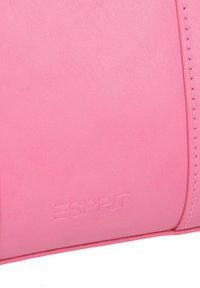 Roze synthetische leren tas met een reli�ëf "ESPRIT" logo, een zachte textuur en contrasterende stiksels langs de randen.