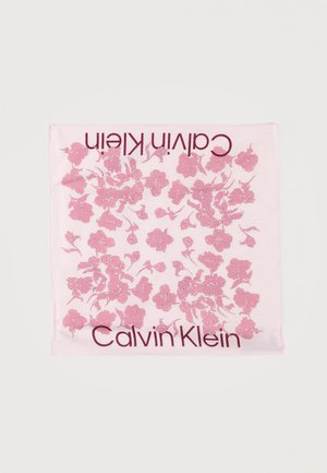 Světlá růžová čtvercová šála s rozptýleným tmavším růžovým květinovým vzorem a nápisem „Calvin Klein“ podél dvou okrajů.