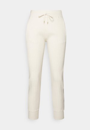 Pantalones jogger de punto blanco con cintura elástica y cordón, puños acanalados en los tobillos y un patrón suave y texturizado.