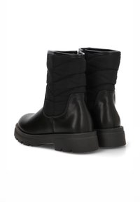 Botines negros con parte superior de tejido acolchado y parte inferior de cuero liso, con una suela de goma resistente y diseño de punta redonda.