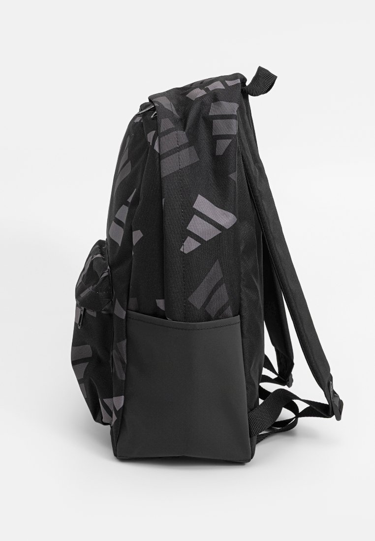 Un sac à dos noir avec des motifs géométriques abstraits gris, poche latérale, bretelles rembourrées et poignée supérieure, montré de côté sur un fond blanc.