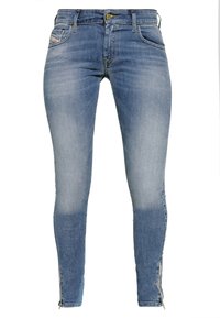 Tajta jeans i ljusblå denim med gradienttvätt, sidodragkedjor vid anklarna och femficksdesign med subtila stygn.