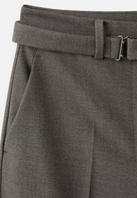 Szare spodnie z teksturowanej tkaniny z dopasowanym paskiem z elegancką metalową klamrą na białym tle.