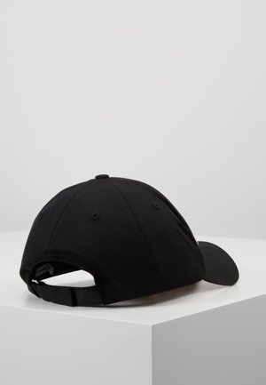 Zwarte baseballpet met verstelbare band, geplaatst op een wit oppervlak tegen een effen grijze achtergrond.