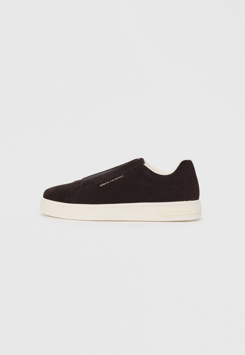 Black suede slip-on sneaker with white rubber sole, featuring a smooth texture and subtle branding on the side. Classic design and structure.