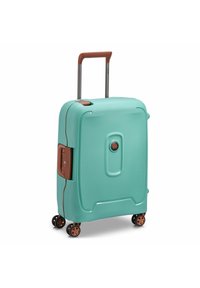 Hard-shell turkise kuffert med en tekstureret finish, brune accenter, et teleskopisk håndtag og fire hjul for mobilitet.