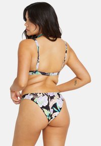 Completo bikini floreale con uno sfondo nero e fiori viola chiaro e verdi. Il top ha spalline regolabili e una chiusura sul retro.