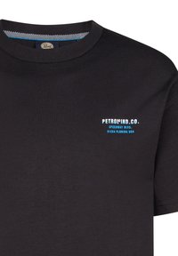 Camiseta de algodón negra con cuello redondo y mangas cortas. Presenta un logo de texto en blanco y azul en la parte izquierda del pecho. Textura suave.