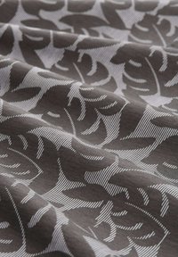 Tela con un fondo gris oscuro que presenta un patrón de hojas blancas en contraste; textura suave con un diseño de rayas sutil.