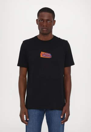 Schwarzes Baumwoll-T-Shirt mit kurzen Ärmeln, das auf der Brust einen bunten rechteckigen Grafikpatch zeigt, der in den Farben Orange, Lila und Blau gehalten ist.