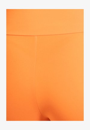 Orange leggings lavet af blødt, strækbart materiale med en glat tekstur. Har høj talje og minimale syningsdetaljer.