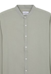 Camicia verde chiaro con colletto a band, realizzata in tessuto morbido. Presenta una consistenza sottile e cinque bottoni bianchi sul davanti.
