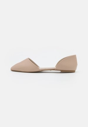 Zapatos planos de color nude con punta puntiaguda, hechos de material sintético liso, con talón abierto y tacón bajo y plano.