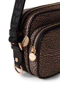 Brown and black patterned crossbody bag with gold hardware, dual zippers, and a textured strap. Features circular metal accents.