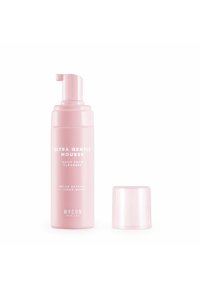 Bottiglia di detergente per il viso rosa con finitura opaca. Il testo include "Mousse Ultra Delicata" e "Estratto di Melone + Acqua di Limone". Cappuccio trasparente accanto.