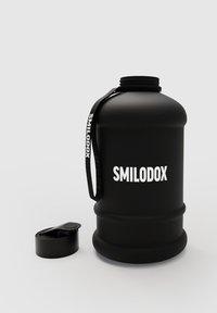 Svart vattenkanna med en matt yta, utrustad med ett handtag och en bred öppning. Ett svart skruvlock ligger bredvid. "SMILODOX"-logotyp på sidan.
