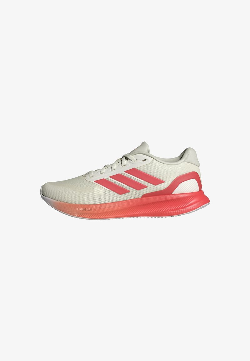 Beige sportschoen met roze accenten, bovenwerk van mesh, drie horizontale strepen, ronde neus en een gestructureerde zool gemarkeerd met "CLOUDFOAM."