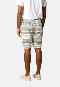 Geprinte shorts met een geometrisch zwart-wit patroon, gemaakt van lichtgewicht stof, met een elastische taille en zijzakken.