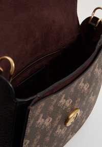 Borsa in pelle marrone e tessuto con motivo carrozza, chiusura a girello dorata e rivestimento interno in suede scuro.