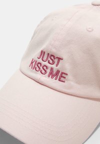 Ružová bavlnená čiapka s vyšitým textom "LEN MA BOZKÁJ" v tmavo ružovej farbe. Disponuje zakriveným okrajom a viditeľným šitím pozdĺž okrajov.