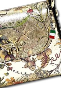 Sac à main en métal doré présentant des motifs floraux et d'insectes complexes. Il possède un accent décoratif en forme d'abeille et un pendentif représentant le drapeau italien.