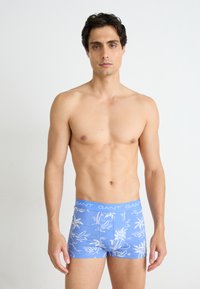 Blaue Boxershorts mit weißem tropischen Muster, aus weichem Stoff gefertigt. Mit einem GANT-Logo-Bund und einer figurbetonten Passform für zusätzlichen Komfort.