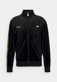 Svart sammetstrackjacka med hög krage. Guldiga detaljer och branding på bröstet och ärmarna. Dragkedjestängning, ribbade manschetter och nederkant.