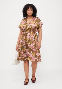 Floral short-sleeve dress featuring a brown background with pink and yellow flowers, cinched waist, and flowing skirt.