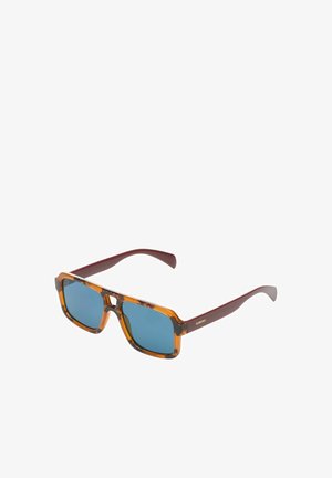 Lunettes de soleil rectangulaires en écaille de tortue avec des verres bleus et des branches rouge foncé, présentant un petit pont en forme de trou de serrure et un logo doré "KOMONO" sur la branche.