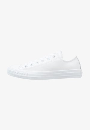 Biały niski sneaker z gumową podeszwą, zapięcie na sznurowadła z metalowymi przelotkami oraz fakturowany nos, widoczny od zewnętrznej strony.