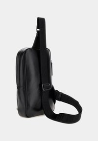 Geantă crossbody din piele sintetică neagră, cu formă rectangulară, curea ajustabilă cu marcaj și textură netedă. Conține un compartiment cu fermoar.