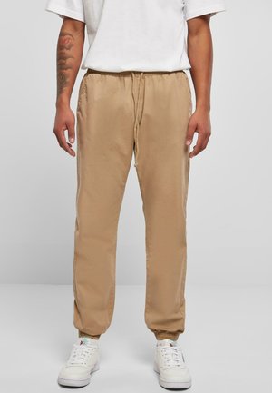 Beige, lette joggebukser med elastisk midjebånd og snøring, med sidelommer og ribbede ankler.
