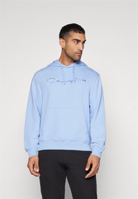 Hellblaues Hoodie mit einer Zugkordelkapuze, Fronttasche und eingesticktem "Champion"-Logo. Weicher Stoff mit gerippten Bündchen und Saum.